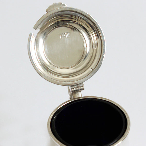 a silver mustard pot dated 1927 and hallmarked for London with a blue glass liner