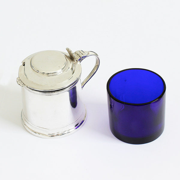 an antique solid silver mustard pot with plain handle and blue liner dated 1927