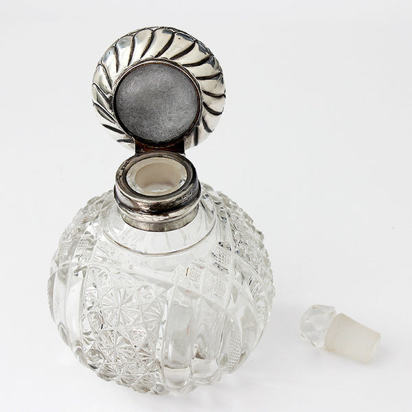 an antique perfume bottle dated 1902 with hallmark and engraving and floral pattern