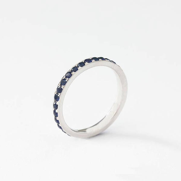 a full eternity ring in 18 carat white gold with 31 round faceted sapphire stones