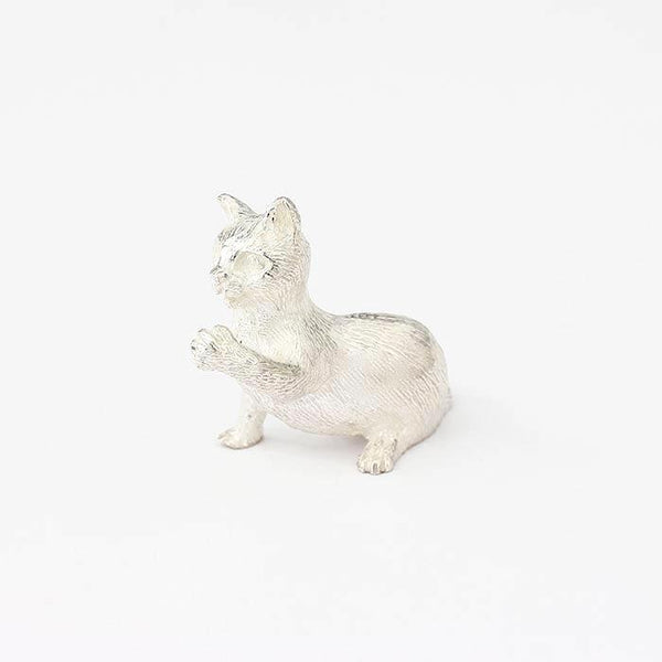 a sterling silver sitting cat with playful paw figure