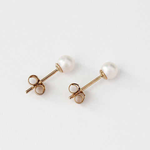 white cultured pearl studs in yellow gold