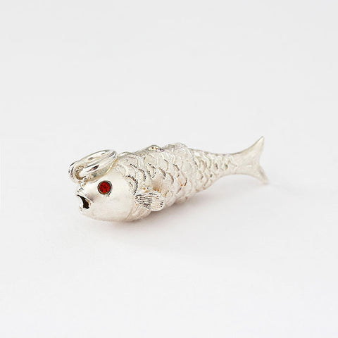 silver moving fish charm with red stone set eyes