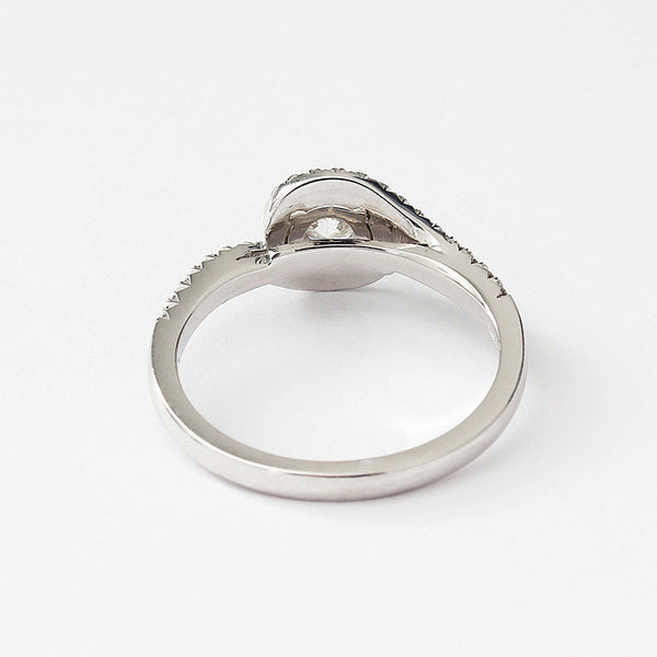 a platinum diamond ring with diamonds in the shoulders and cluster style