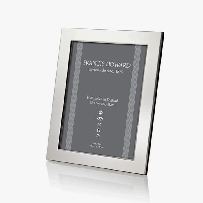 sterling silver photo frame made in sheffield with a wide plain finish and black wooden effect on the back