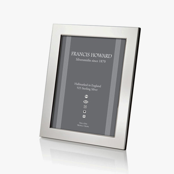 sterling silver photo frame made in sheffield with a wide plain finish and black wooden effect on the back